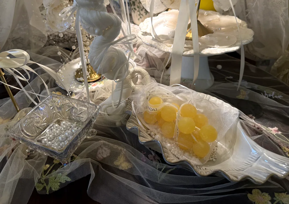 Yellow grape soap in an organza bag on a shell dish